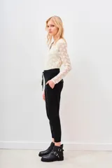 Pantalón tipo babucha color verde militar, confeccionado en gabardina elastizada, con ajuste en tobillos y cintura regulable con cordón a tono. Cuenta con bolsillos diagonales en el frente y bolsillos con solapa y botón en la parte trasera.
