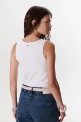 Musculosa blanca con breteles finos y detalle metálico en uno de los breteles.
