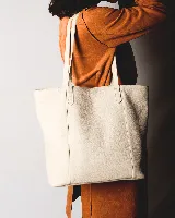 Bolso tote de cuero color bordó, con broche de cierre, bolsillo interior y porta llaves.