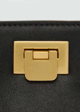 Bolso tipo bucket negro con asa corta y cierre metálico dorado.