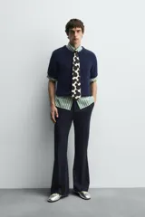 Cárdigan azul marino de manga corta tejido en hilatura con lana y alpaca, de textura suave. Tiene cuello redondo, rib en los bordes y cierre frontal con botones. Edición especial Harry Lambert for Zara x Disney.