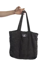 Bolso tipo tote bag negro de denim acolchado con logo estampado al frente.