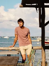 Camiseta de manga corta color rosa con cuello redondo y logo bordado en el pecho.