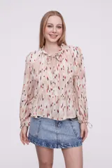 Blusa con estampado multicolor, de corte holgado y mangas largas, con detalle de lazo en el cuello.