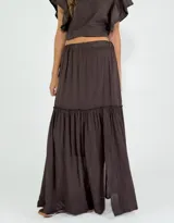 Pollera larga color crudo, de corte amplio y con volados.