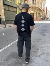 Remera negra de corte holgado con estampado en la espalda con la palabra LOVE en letras blancas y las palabras Loyal, Observant, Valiant y Enjoyment.