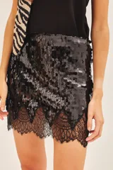 Minifalda negra con lentejuelas y encaje en el ruedo.