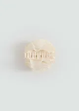 Pinza para el pelo color crema con forma de flor con textura.