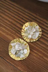 Aros tipo caravana con base redonda dorada con textura y apliques de perlas irregulares.