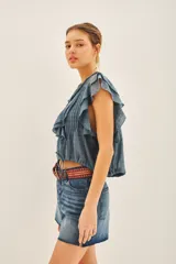 Camisa color crema de corte corto con escote redondo, mangas cortas con volados y jareta ajustable en el ruedo.