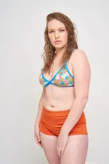 Conjunto de bikini con corpiño triangular con tirantes finos y bombacha clásica, ambos con estampado animal print multicolor y ribetes negros.