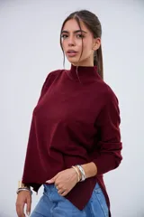 Sweater de punto color bordó, con cuello alto, mangas largas y aberturas laterales en el dobladillo.