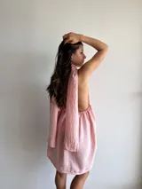 Vestido corto rosado con escote halter y falda acampanada.