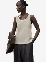 Musculosa de punto calado color crema, con escote redondo y sisas amplias. Tejido de malla con trama abierta.