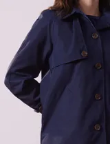 Gabardina impermeable color beige, marca Weatherproof, con abertura central con botones, bolsillos delanteros y capucha desmontable.