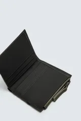 Billetera color verde oliva de acabado engomado con monedero. Tiene compartimento principal para billetes, seis posiciones internas para tarjetas y dos externas. En uno de los laterales tiene un monedero con cierre de cremallera.
