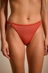 Bombacha de bikini color ladrillo con detalle de aros dorados en los laterales.