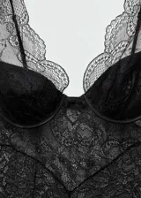 Vestido de encaje negro con escote en V y tirantes finos.