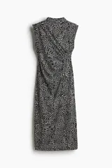 Vestido midi negro con estampado de manchas blancas, sin mangas, de punto elástico, corte ajustado, cuello alto y costura curva fruncida en un lateral para conseguir un efecto drapeado que realza la figura.