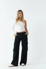 Top asimétrico blanco de una sola manga con jaretas ajustables en ambos lados del torso para regular el largo.