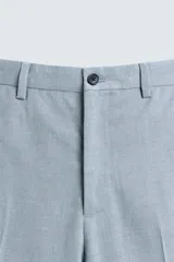 Pantalón de vestir celeste claro, corte slim fit, con bolsillos laterales y traseros de doble vivo con botón. Cierre frontal con cremallera y botón.
