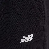 Pantalón de jogging negro con logo de New Balance estampado en blanco en la pierna izquierda.