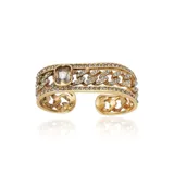 Brazalete rígido dorado con diseño de eslabones y apliques de strass. Presenta un cristal facetado rectangular en el centro.