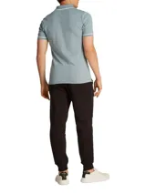 Chomba de piqué celeste con cuello polo, mangas cortas y corte slim. Presenta tapeta de dos botones, logo CK bordado en el pecho y ribetes blancos en cuello y mangas.