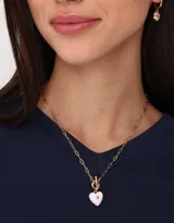 Collar corto con cadena dorada y dije de corazón esmaltado color rosa.