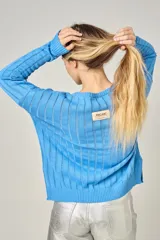 Sweater de punto negro con escote en V y rayas verticales plateadas.