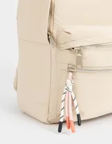 Mochila negra de tela deportiva con bolsillo frontal con cierre y tirador de cordón y goma. Tiene correas regulables, manija superior, doble cierre superior y etiqueta de goma.