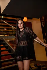 Remerón oversize de encaje negro con cuello redondo y mangas cortas.