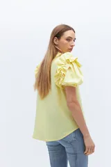 Camisa amarilla de lino con cuello mao y mangas cortas abullonadas con volados.