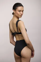 Bombacha de bikini negra de tiro alto, con textura acanalada y cobertura completa en la parte trasera.