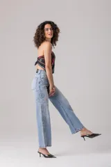 Pantalón de jean celeste de tiro alto, corte recto y apliques de strass plateados en los laterales.