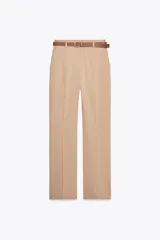 Pantalón de vestir color beige, de tiro alto y corte recto. Incluye cinturón marrón.