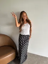 Pollera larga de fibrana, color negro con estampado de lunares blancos. Presenta cintura elástica y corte amplio.