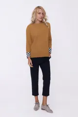 Sweater azul marino de tejido de punto con cuello redondo y puños con diseño a cuadros blancos y negros.