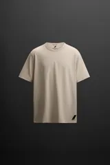 Camiseta relaxed fit color beige confeccionada en tejido con mezcla de algodón, cuello redondo, manga corta y logo estampado en el bajo. Zara Athleticz.