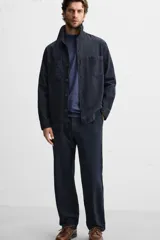 Pantalón azul marino de corte recto, confeccionado en tejido de algodón y lino. Tiene cintura elástica ajustable con cordón, bolsillos delanteros y traseros de vivo. Cierre frontal con cremallera y botón.