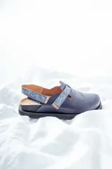 Zuecos azul marino con suela negra y tira trasera estampada en tonos azules.