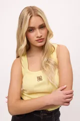 Musculosa marrón de lycra y algodón, con logo bordado en color amarillo.
