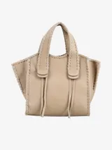 Cartera tipo tote de cuero color beige con costuras decorativas en hilo blanco.