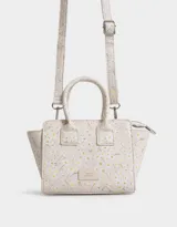 Cartera mini city de cuerina negra estampada con flores blancas. Tiene correa desmontable y doble asa corta.