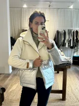 Campera con parte superior de paño de lana color crema y parte inferior impermeable plateada. Forrada con peluche y capucha desmontable.