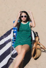 Vestido corto de playa color verde con calados y rayas horizontales.