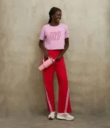 Remera corta de manga corta color rosa claro, con cuello redondo y estampado frontal que incluye el texto "Sporting Club" y el número "87" en rojo.