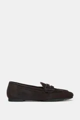 Zapato mocasín de mujer, color marrón chocolate, confeccionado en serraje. Tiene detalle de tira en la parte delantera y acabado en punta redonda.
