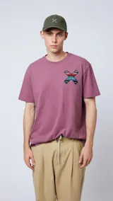 Remera manga corta color lila con cuello redondo y estampado en el pecho con forma de equis (X) con motivos geométricos en colores.