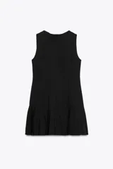 Vestido corto negro sin mangas, con cuello redondo y falda con tablas. Cierre trasero con cremallera oculta.